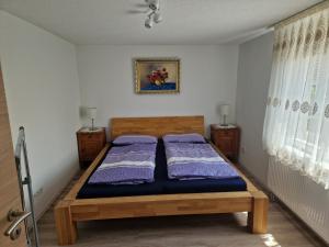 a bedroom with a bed with purple sheets and two windows at FERIENHAUS AyNa, direkt an der Schweizer Grenze in Bad Säckingen