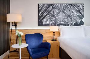 ein Schlafzimmer mit einem Bett und einem blauen Stuhl in der Unterkunft Radisson Blu Toronto Downtown in Toronto