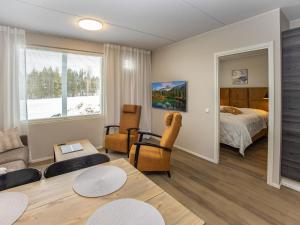 a living room with a bedroom and a bed and a table at Holiday Home Levistar vi as- 6106 by Interhome in Levi