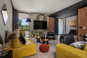 a living room with a yellow couch and chairs at Villa She Luxury by IstriaLux in Grožnjan