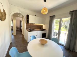 a kitchen with a table and blue chairs in a room at Vila Vera Seafront Apartments in Sumartin