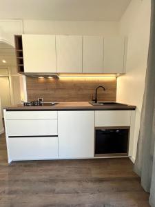 a kitchen with white cabinets and a sink at Vila Vera Seafront Apartments in Sumartin