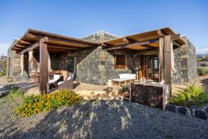 a stone house with a porch and a patio at Dammuso Luna - Piscina Privata con Vista Mare in Pantelleria