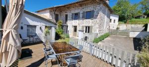 a patio with a table and chairs and a building at O Beaujolais Chiroubles in Chiroubles