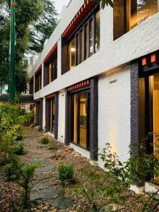 a building with a pathway in front of it at Pema Thang Guest House Mcleodganj in Dharamshala