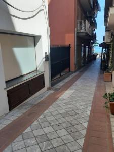 an empty street with a large tv on the side of a building at A 20 passi dal mare in Giardini Naxos