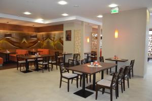 jadalnia ze stołami i krzesłami w restauracji w obiekcie Hotel Via Baltica w mieście Łomża