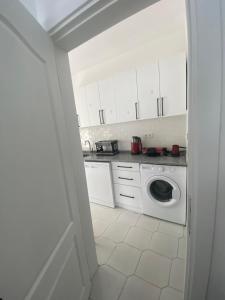 a white kitchen with a washing machine in it at Bodrum Nuran Boutique Apart in Bodrum City