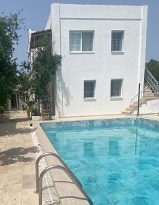 a swimming pool in front of a building at Bodrum Nuran Boutique Apart in Bodrum City