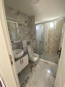 a bathroom with a toilet and a sink and a shower at Bodrum Nuran Boutique Apart in Bodrum City