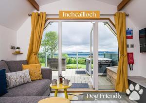 a living room with a couch and a sliding glass door at Bonnie Barns - Adults Only Luxury Lodges with hot tubs in Luss