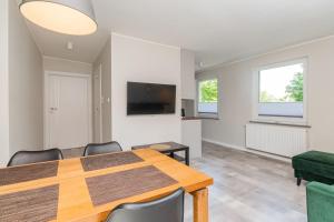 ソポトにあるSzary & Zielony by Grand Apartmentsのテーブルとテレビのあるダイニングルーム