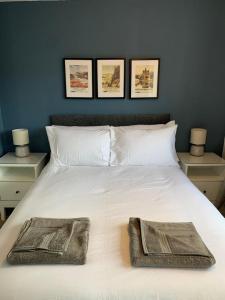 a bedroom with a white bed with two towels on it at 3 Bedroom Cosy Home In Fife in Cardenden