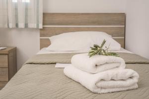 a bed with white towels on top of it at Leonidas Family Apartment 1 in Pómbia +56 photos