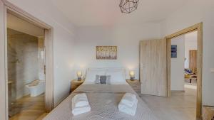 a bedroom with a large bed with two pillows at Leonidas Family Apartment 1 in Pómbia