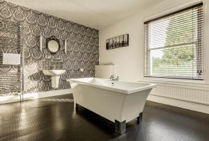 a white bathroom with a tub and a sink at Malvern View in Cheltenham