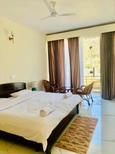 1 dormitorio con 1 cama grande con sillas y ventana en Lake 1 Estate, en Morni 30 fotos más