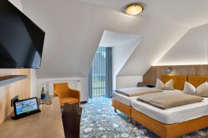 a hotel room with two beds and a flat screen tv at Landhotel Seerose in Langenzenn +124 photos
