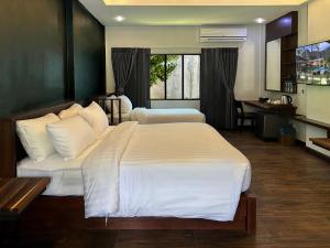 a hotel room with two beds and a desk at Eco Inn Cottage by Aonang Hill in Ao Nang Beach