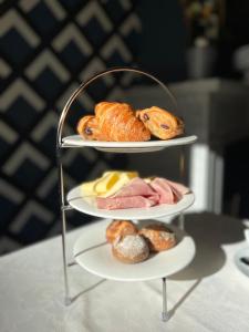 a three tiered stand with three plates of pastries and bread at Radici in Nieuwpoort