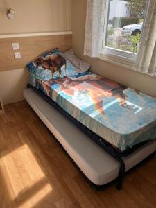 a bed sitting in a room with a window at Mobil Home avec WIFI -6-8 Personnes in Lattes +6 photos