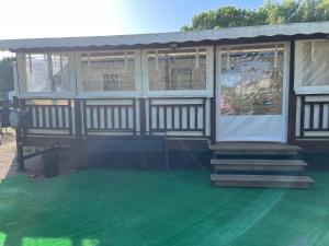 a house with a green floor and a building with windows at Joelle et Patrick in Lattes