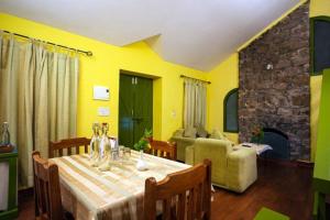 a dining room with a table and a couch at Mountain Club Resort Munnar in Chinnakanal