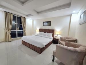 纳兰恩Iconic Hotel Naran的一间有一张大床和两把椅子的卧室