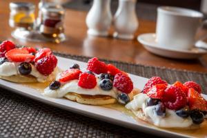 a plate of pancakes with berries and whipped cream at Malvern View in Cheltenham +24 photos