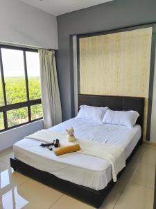 une chambre avec un lit sur lequel est assis un chat dans l'établissement Klebang GX Homestay City & Partial Seaview P0805 with Youtube, TV Games & Toys, à Malacca 15 autres photos