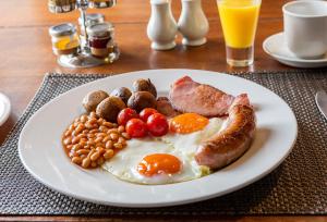 a plate of breakfast food with eggs sausage and beans at Malvern View in Cheltenham +24 photos