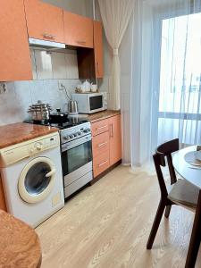 a kitchen with a stove and a washing machine at Центр Торговиця 1 кімнатні апартаменти in Ternopilʼ +5 photos