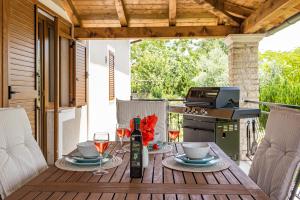a wooden table with glasses of wine on a patio at Family retreat House Begonija with pool and BBQ in Burići