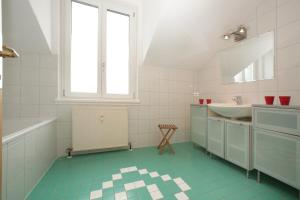 biała łazienka z umywalką i lustrem w obiekcie City Apartments Mozart w mieście Zell am See +37 zdjęć