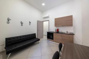 a living room with a black couch in a kitchen at Casa Vacanze Nemesi TYCHE in Salerno