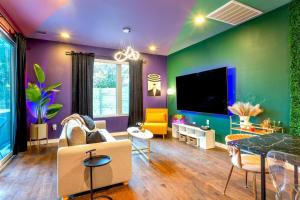 uma sala de estar com paredes roxas e verdes em Hot Tub Club - Rainey Street - 6 min walk em Austin