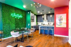 a kitchen with a green wall with a table and chairs at Hot Tub Club - Rainey Street - 6 min walk in Austin