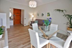 une salle à manger avec une table en verre et des chaises blanches dans l'établissement Valentine's Home, à Viareggio 30 autres photos