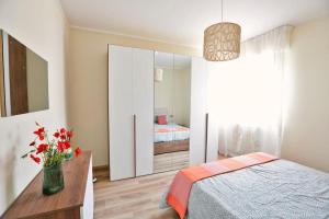 - une chambre avec un lit et un vase de fleurs dans l'établissement Valentine's Home, à Viareggio