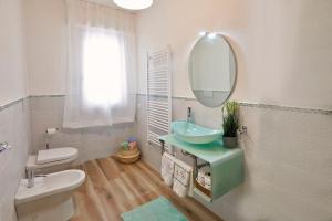 une salle de bains avec lavabo, toilettes et miroir dans l'établissement Valentine's Home, à Viareggio