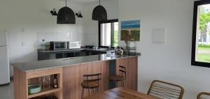 a kitchen with a counter with chairs and a table at Casa en Laguna Soto Sur in Corrientes