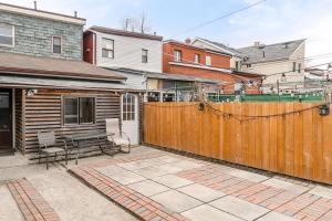 a backyard with a wooden fence and a picnic table at Pet-Friendly 3BR Apartment - Ossington Ave in Toronto