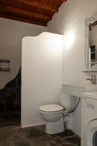 a white bathroom with a toilet and a sink at Two Houses Lighthouse Apartment in Fanari