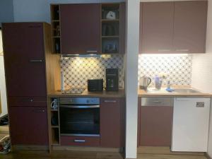cocina con armarios morados y fogones en Ferienwohnung Harzer Sonnenbaum, en Sankt Andreasberg