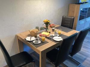 una mesa de madera con comida y vasos de zumo de naranja en Ferienwohnung Harzer Sonnenbaum, en Sankt Andreasberg