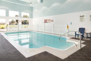 a large swimming pool with blue water in a building at Days Inn by Wyndham Leamington in Leamington