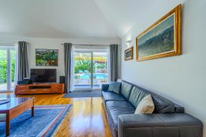 a living room with a couch and a tv at Villa Župa - Heated Pool, Tennis & Sports Complex in Župa