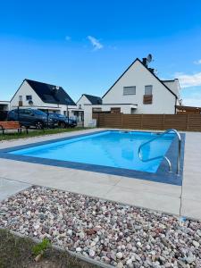a swimming pool with a slide in a yard at Coast House 25 -TRZĘSACZ SUNNY SIDE BALTIC in Trzęsacz