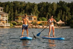a man and a woman on paddle boards in the water at Insel der Sinne Naturhotel in Görlitz