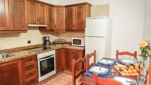 a kitchen with a table and a white refrigerator at CHC - La Oliva II in Buenavista del Norte